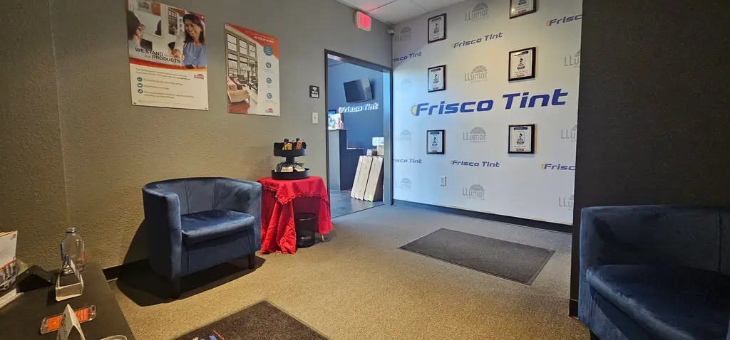 The Frisco Tint customer waiting area with seating and a branded wall
